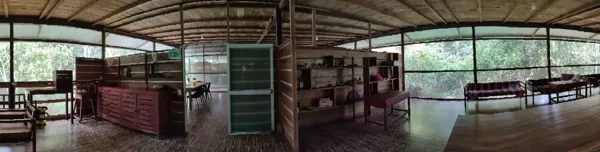 Spacious interior of a wooden eco-lodge in the Peruvian Amazon, featuring open-plan design