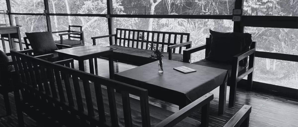Eco-conscious office interior in the Amazon rainforest with wooden furniture and jungle view through glass walls — sustainable workspace in Peru